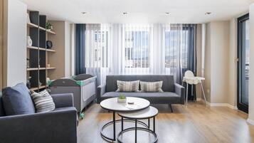 A modern living room with a sofa, a coffee table, and a bookshelf.