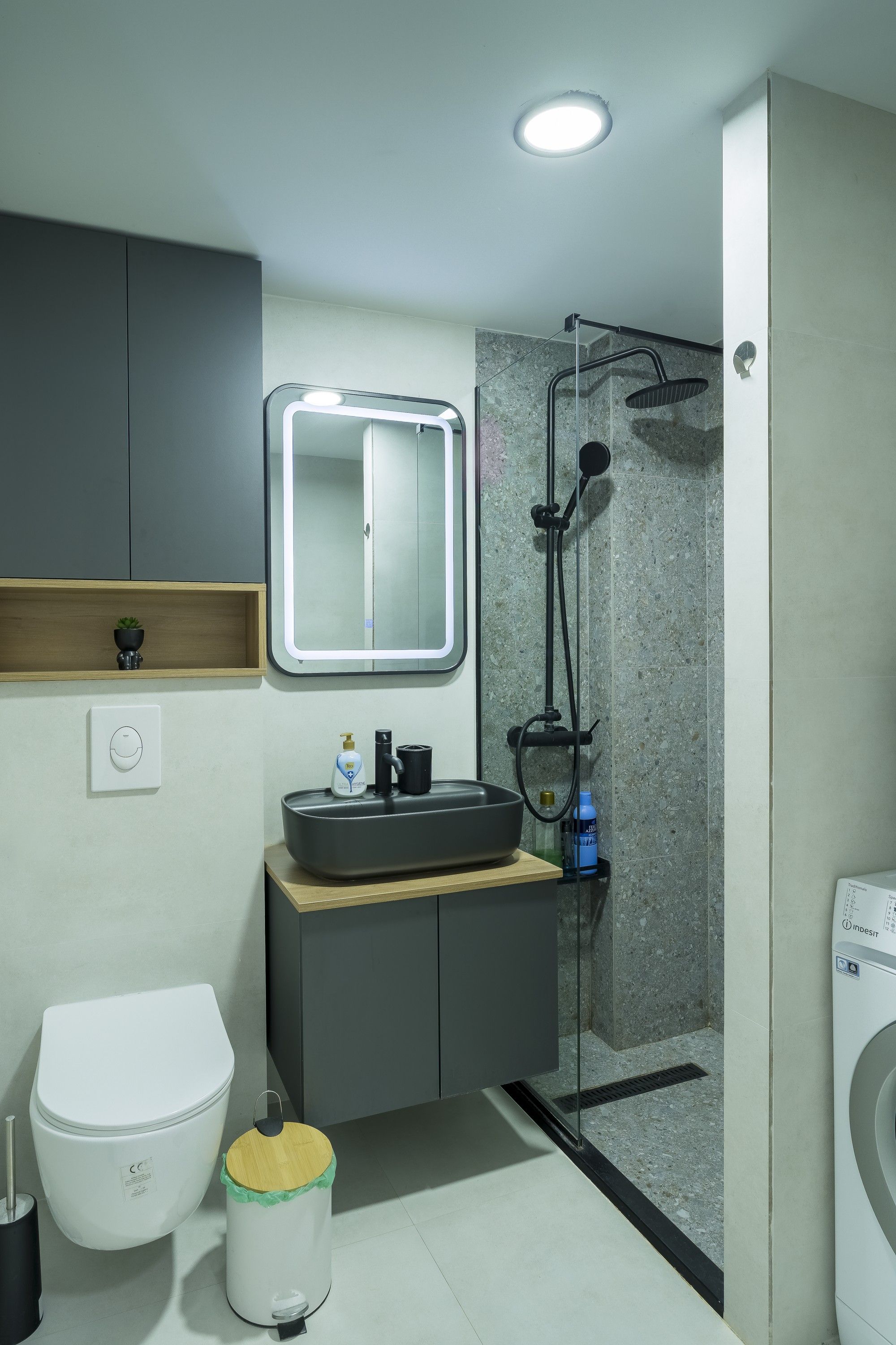 A modern bathroom with a built-in sink, mirror, and shower.