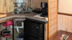 A compact kitchen with a microwave, coffee maker, and a small refrigerator.