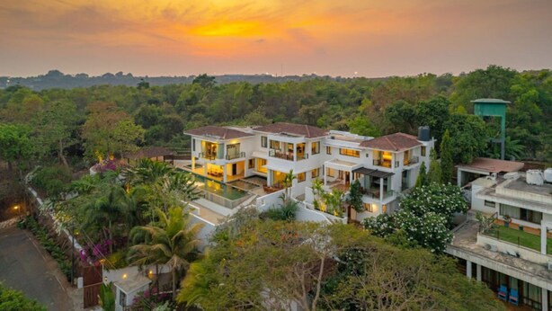 A modern multi-story house with a swimming pool, surrounded by lush greenery. - Cliffhouse by Hireavilla -5br w Pvt Pool in Saipem (Candolim)