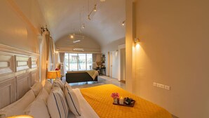 A spacious bedroom with a large bed, a bedside table, and a view of the outdoors. - Legacy by Hireavilla Natgeo Spot w Field Views (Siolim)