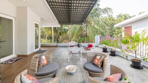 An outdoor patio with wicker furniture, a covered area, and potted plants. - Lux 5BR Villa in Anjuna Perfect for Groups Aria (Anjuna)