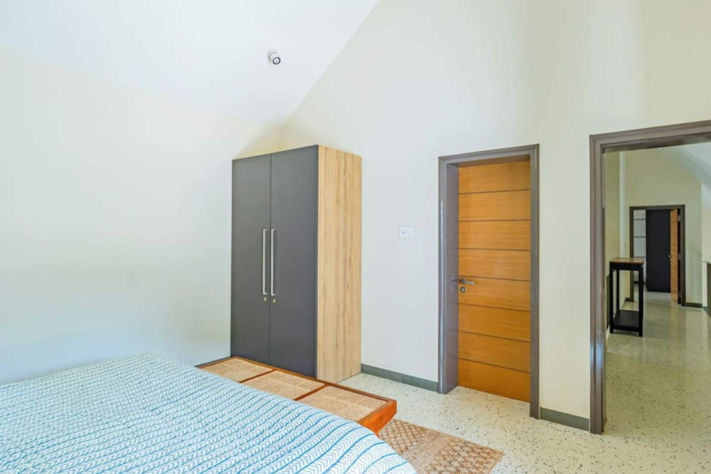 Un dormitorio con cama, armario y puerta que da a otra habitación.