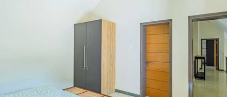 Un dormitorio con cama, armario y puerta que da a otra habitación.