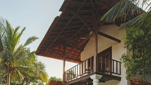 A two-story building with a balcony, a pool, and tropical landscaping. - Salt by Hireavilla - 4BR w Heated Pool in Siolim (Siolim)