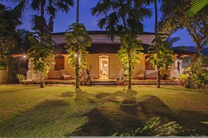 A well-lit building with a covered porch, surrounded by palm trees and potted plants. - Salt by Hireavilla - 4BR w Heated Pool in Siolim (Siolim)