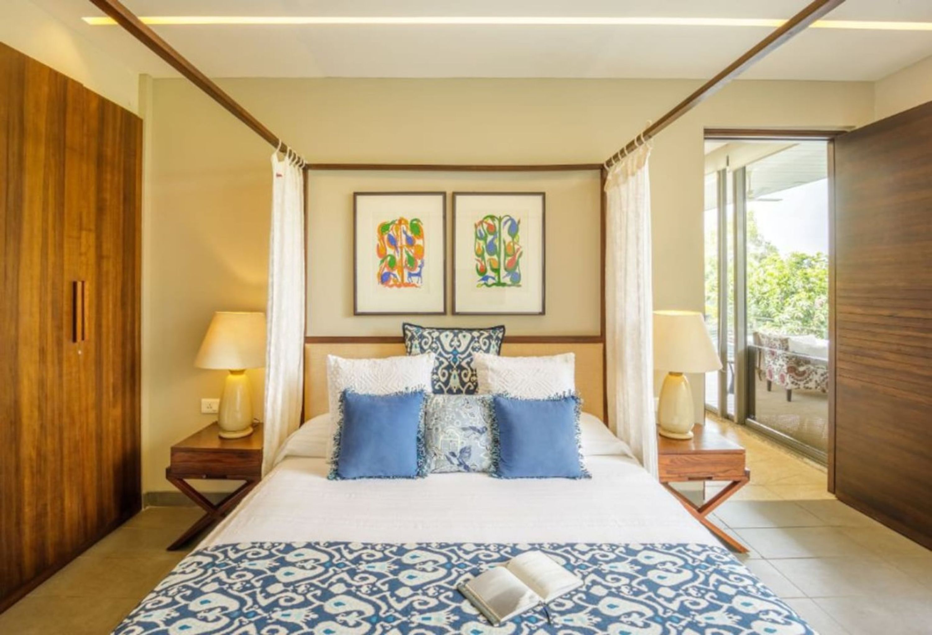 Una camera d'albergo moderna con un letto grande, due lampade da comodino e vista sull'esterno.