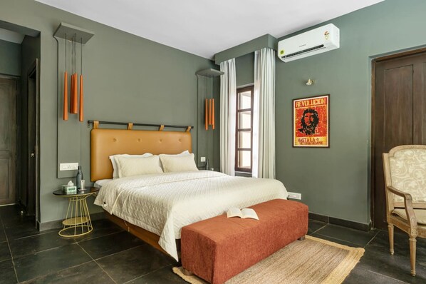 Un dormitorio con cama, mesita de noche y una silla.