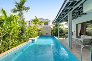 A swimming pool with a pergola and lounge chairs, surrounded by tropical plants. - Inaari - 5bhk With Private Pool Near Anjuna Beach (Anjuna)