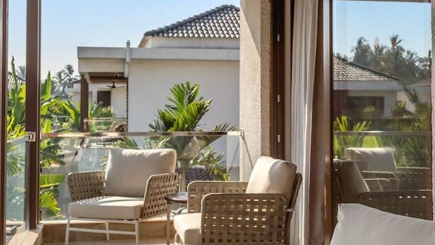 Zona relax all'aperto, riparata, con mobili in vimini e ventilatore a soffitto.