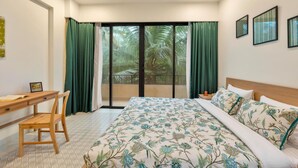 A bedroom with a bed, a desk, and a chair. - Sol Banyan by Hireavilla - 1BR w Pool in Candolim (Candolim)