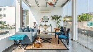 Una sala de estar moderna con sofá, sillón, mesa de centro y objetos decorativos.