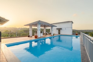 A rooftop swimming pool with a pergola, lounge chairs, and a small building. - Irene Altezza by Hireavilla -2br w Pool in Pilerne (Marra)