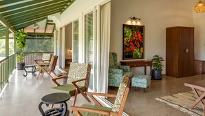 A spacious living area with a balcony, wooden furniture, and a large painting. - Villa Verona by Hireavilla 6BR With Pool in Parra (Parra)