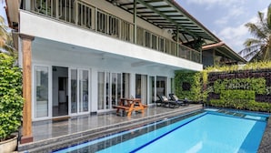 A modern hotel with a swimming pool, outdoor seating, and a covered patio area. - Villa Verona by Hireavilla 6BR With Pool in Parra (Parra)