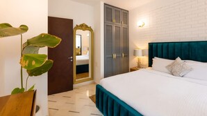 Une chambre à coucher avec un lit, une armoire, un miroir et une plante.