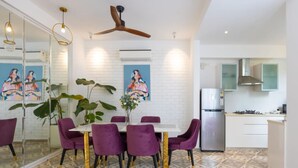 Une cuisine moderne avec des meubles blancs, un réfrigérateur en acier inoxydable et une cuisinière à gaz.