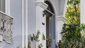 A building with a white facade, a staircase leading to an entrance, and a black chandelier. - Villa Jaanzu - 4bhk With Private Pool in Saligao (Calangute)
