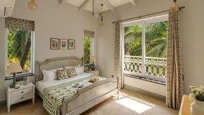 A bedroom with a bed, nightstands, a ceiling fan, and a window with curtains. - The Hornbill Villa - 3bhk With Pvt Pool in Saligao (Calangute)