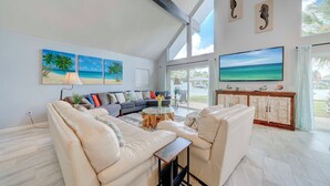 A spacious living room with a large sofa set, a coffee table, and artwork on the walls. - Dolphin Days Lagoon Escape (Panama City)