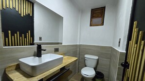 Un bagno moderno con un lavabo rettangolare, un water e una piccola finestra.