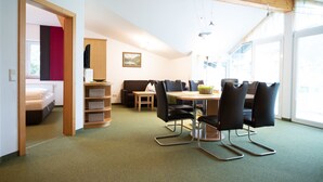 A modern room with a dining area, a sofa, and a bed. - Haus Katharina - Kitzsteinhornblick (Kaprun)