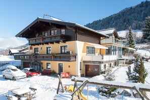 Un hôtel à plusieurs étages doté d'un télésiège, entouré d'un paysage enneigé et adossé à une chaîne de montagnes.