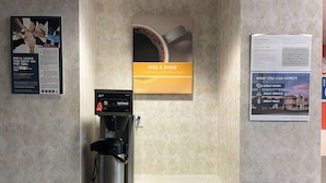 A coffee machine with a coffee cup and a sign above it that says "RISE & SHINE". - Studio 6 – Las Cruces, NM - Telshor (Las Cruces)