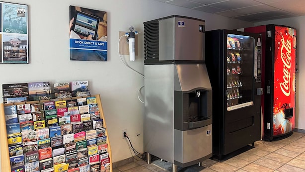 A vending machine, a refrigerator, and a display of travel brochures. - Studio 6 – Las Cruces, NM - Telshor (Las Cruces)