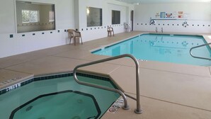 An indoor swimming pool with two lanes, safety railings, and clear signage including pool capacity and no diving allowed. - Studio 6 – Las Cruces, NM - Telshor (Las Cruces)