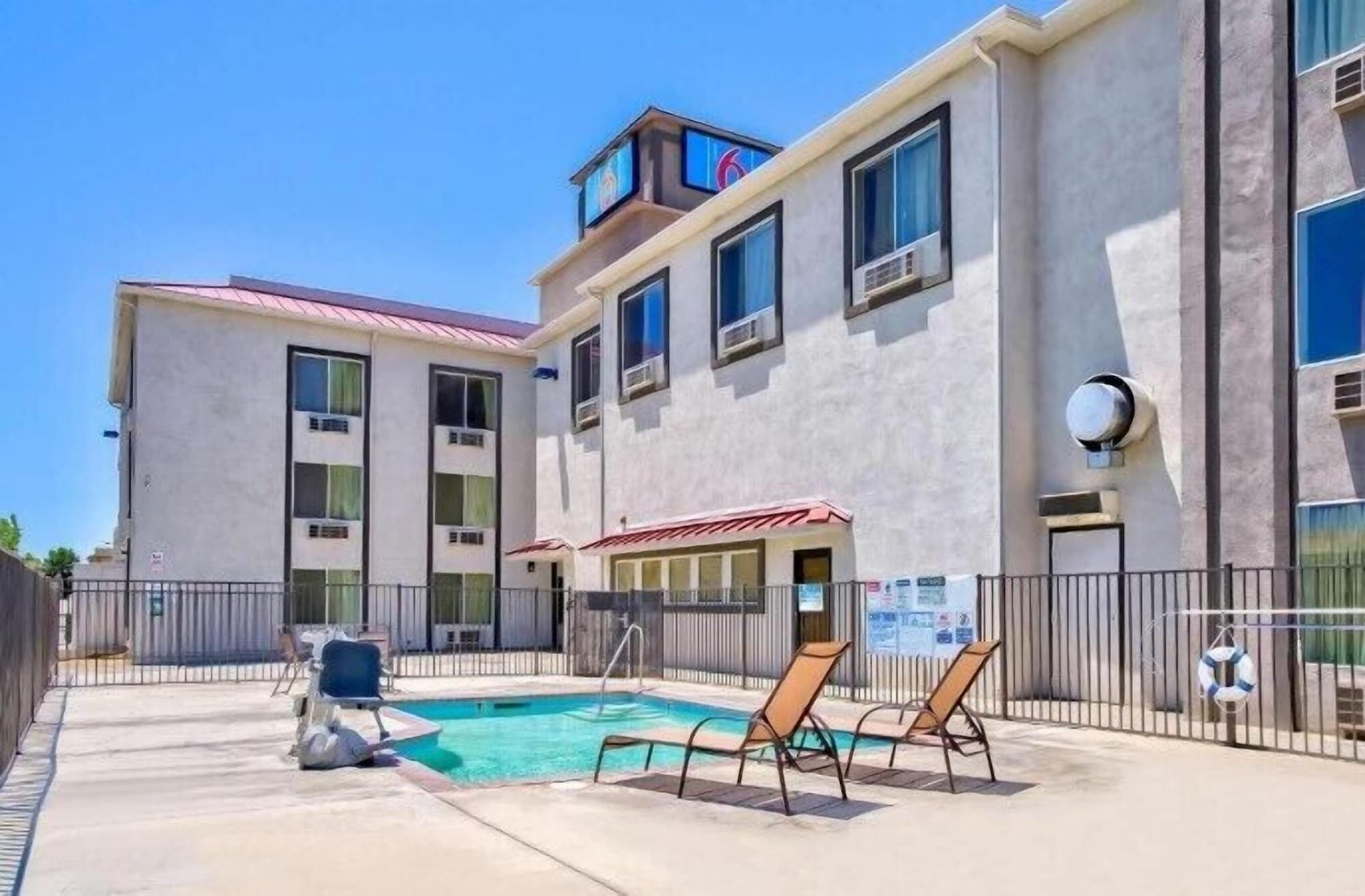 A building with a swimming pool, outdoor seating, and a lifebuoy.