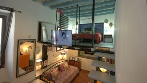 A room with a bed, a mirror, a television, and a window. - 340 Livingtarifa Warhol (Tarifa)