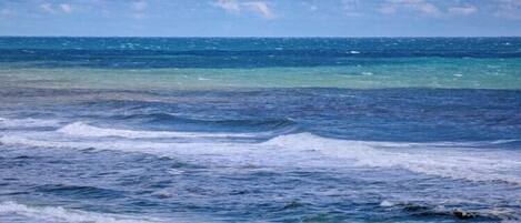 Una playa con olas y un cielo nublado.