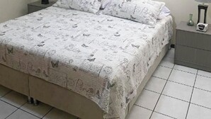 A bedroom with a bed, two nightstands, a wall-mounted painting, and a tiled floor. - New Apt in GDL Near Cathedral  (Guadalajara)