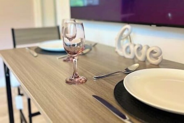 Een eettafel met een wijnglas, een bord en bestek.