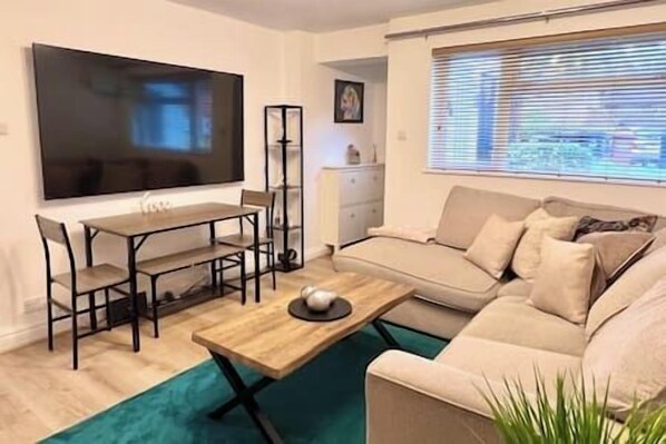 A living room with a TV, sofa, and coffee table.