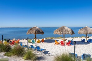 Ein Strand mit bunten Liegestühlen und Reetdachschirmen.