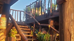 A wooden staircase with a rustic design, surrounded by potted plants and a wooden railing.