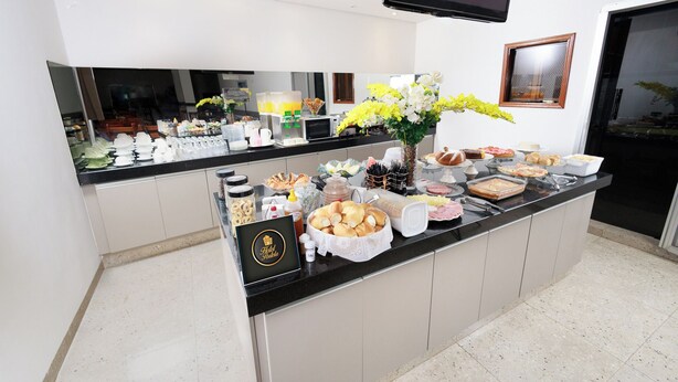 Un buffet proposant une variété de plats et agrémenté d’un vase de fleurs.