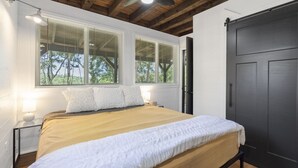 A bedroom with a bed, two bedside tables, a ceiling fan, and a dark door. - No Regrets at the North Fork River (Dawt)