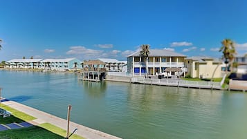 A waterfront hotel with multiple buildings, a dock, and a clear blue sky.