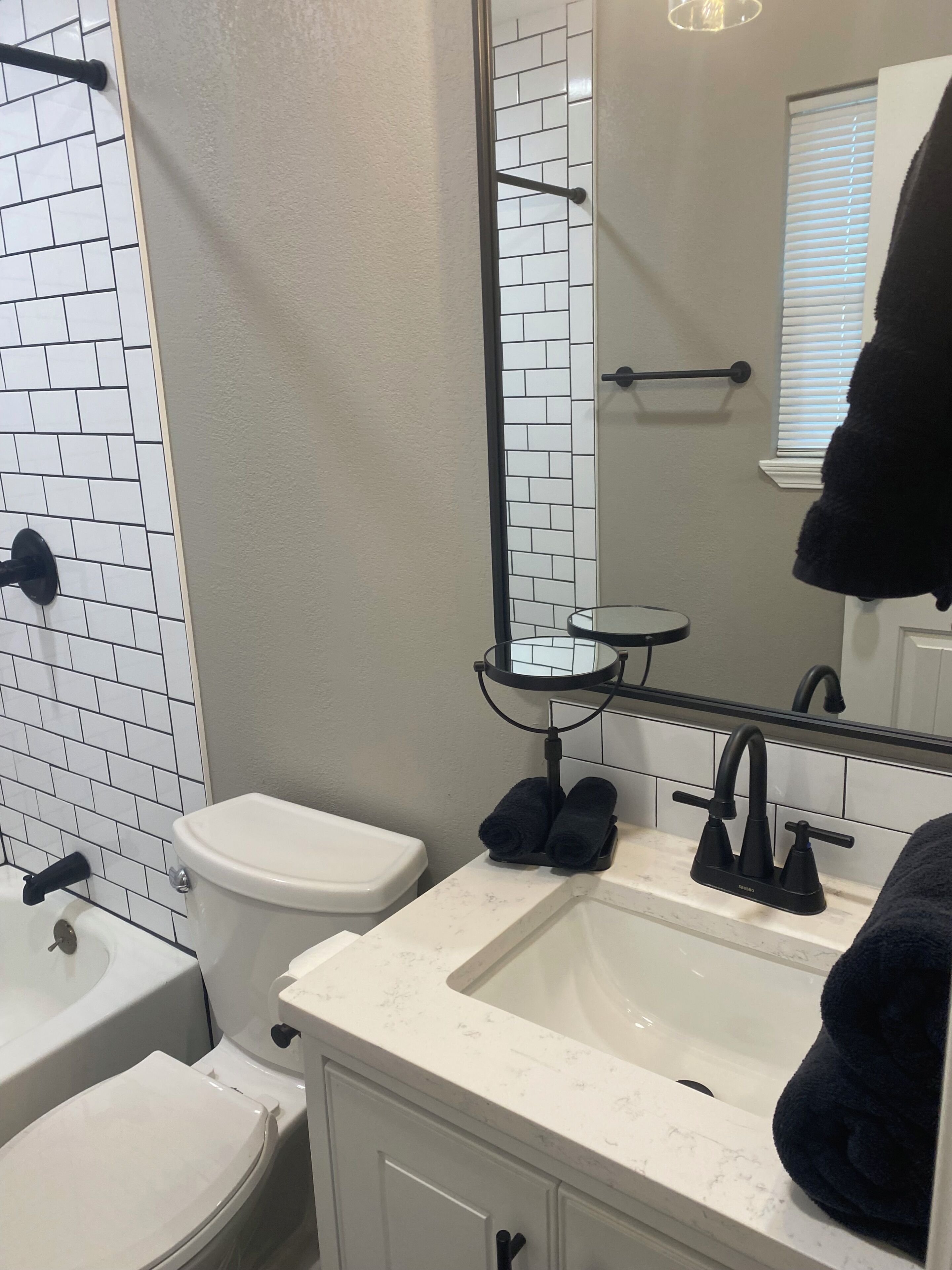 A bathroom with a white toilet, a sink with a mirror above it, and a towel rack.