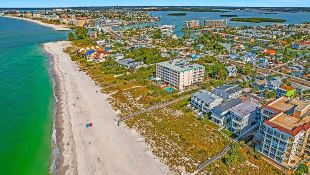 An aerial view of a coastal town with a sandy beach, residential buildings, and a marina. - Sunshine Lane by Distinctive Beach Rentals (Treasure Island)