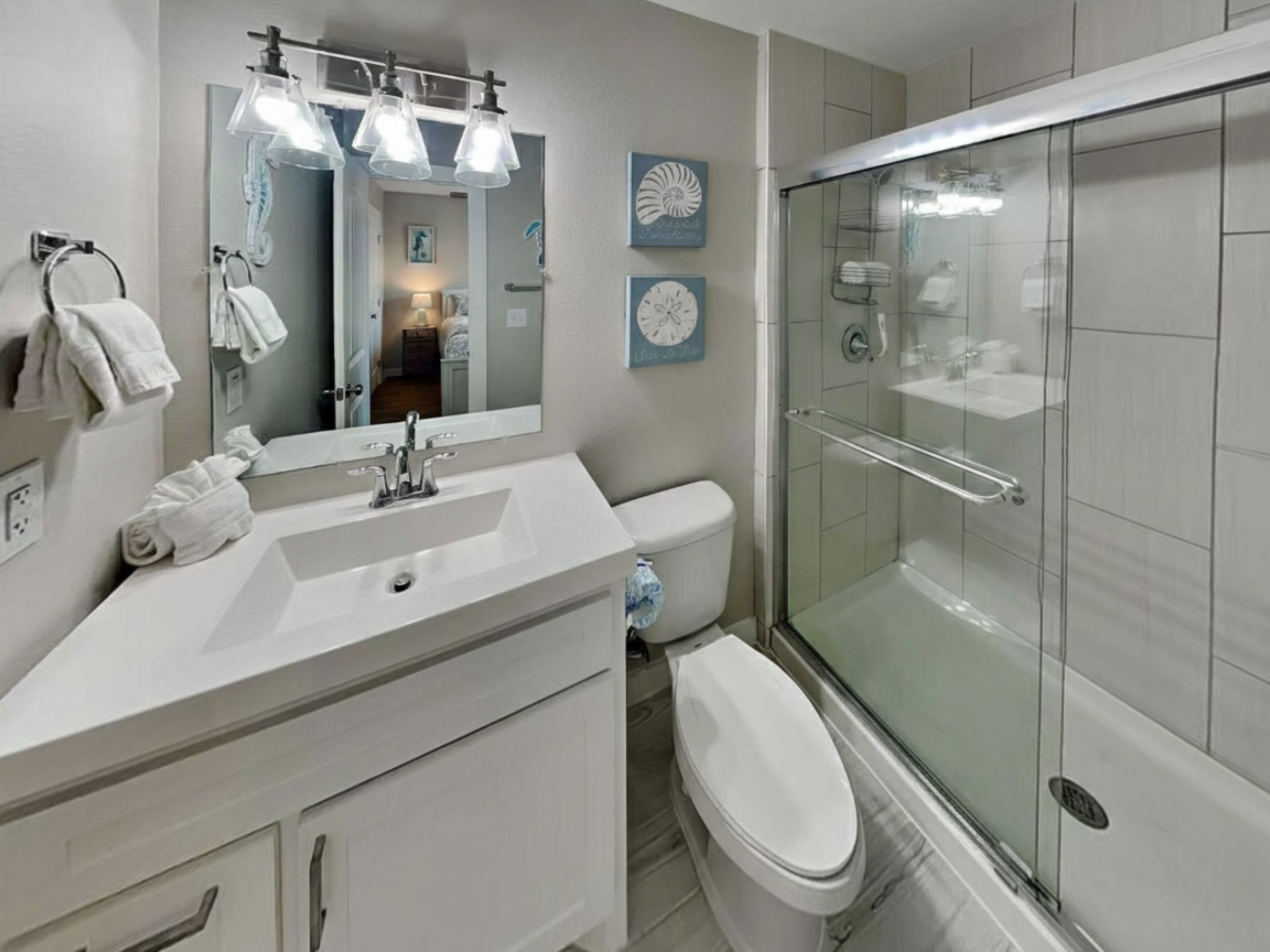 Ein modernes Badezimmer mit Duschkabine aus Glas, einem weißen Waschbecken und einer Toilette.