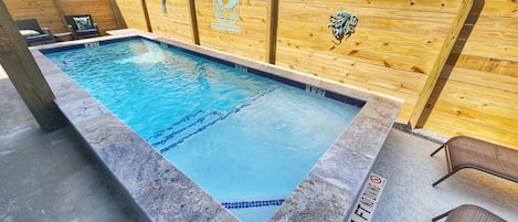 A rectangular pool with a wooden fence and a sign indicating a depth of 3 feet.