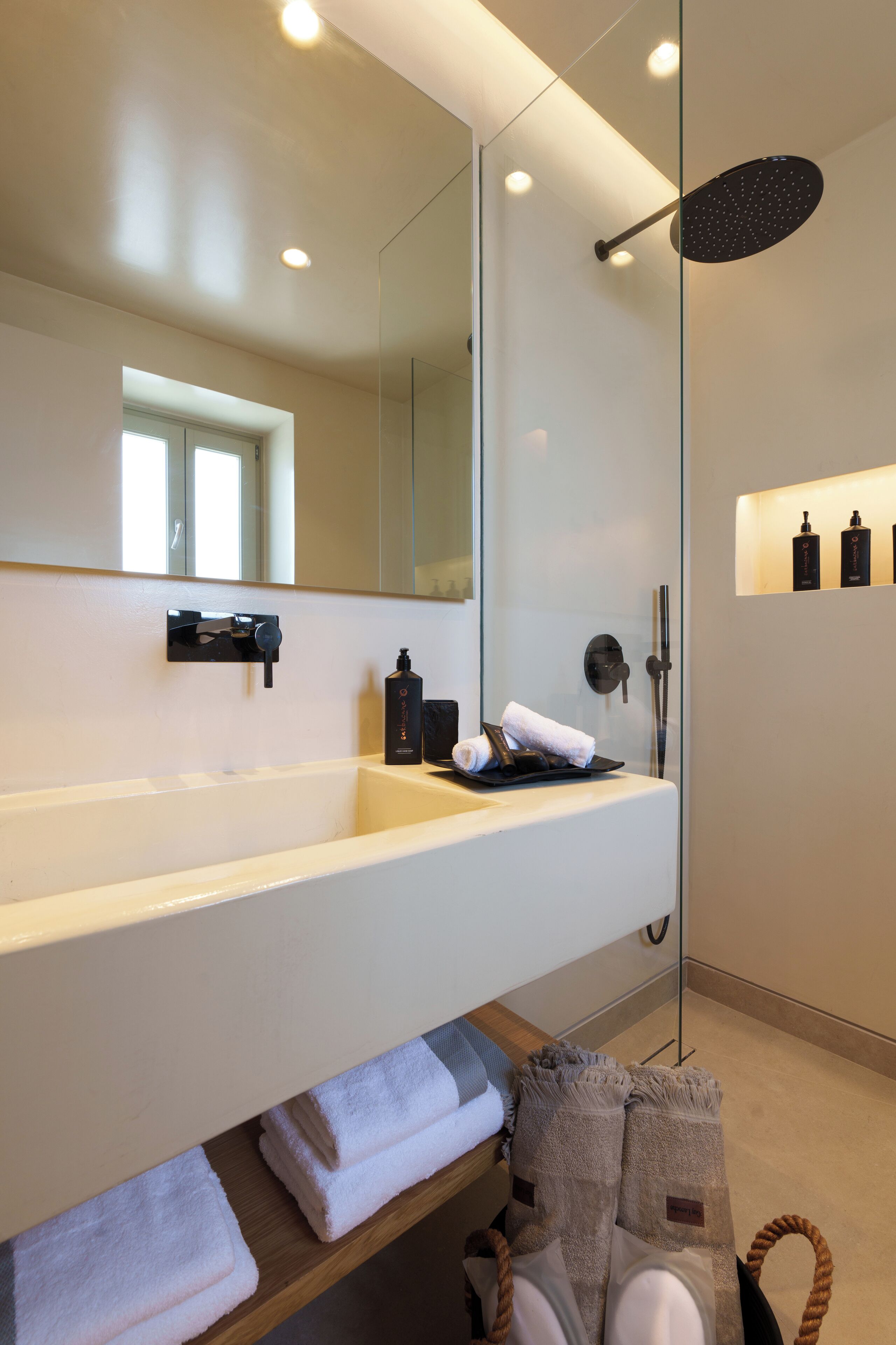 A modern bathroom with a large mirror, a bathtub, and a shower area.