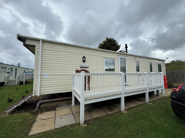 A mobile home with a porch, a nameplate, and a visible chimney. - Heacham Beach Caravan-sleeps 6-pets Ok-parking (King's Lynn)