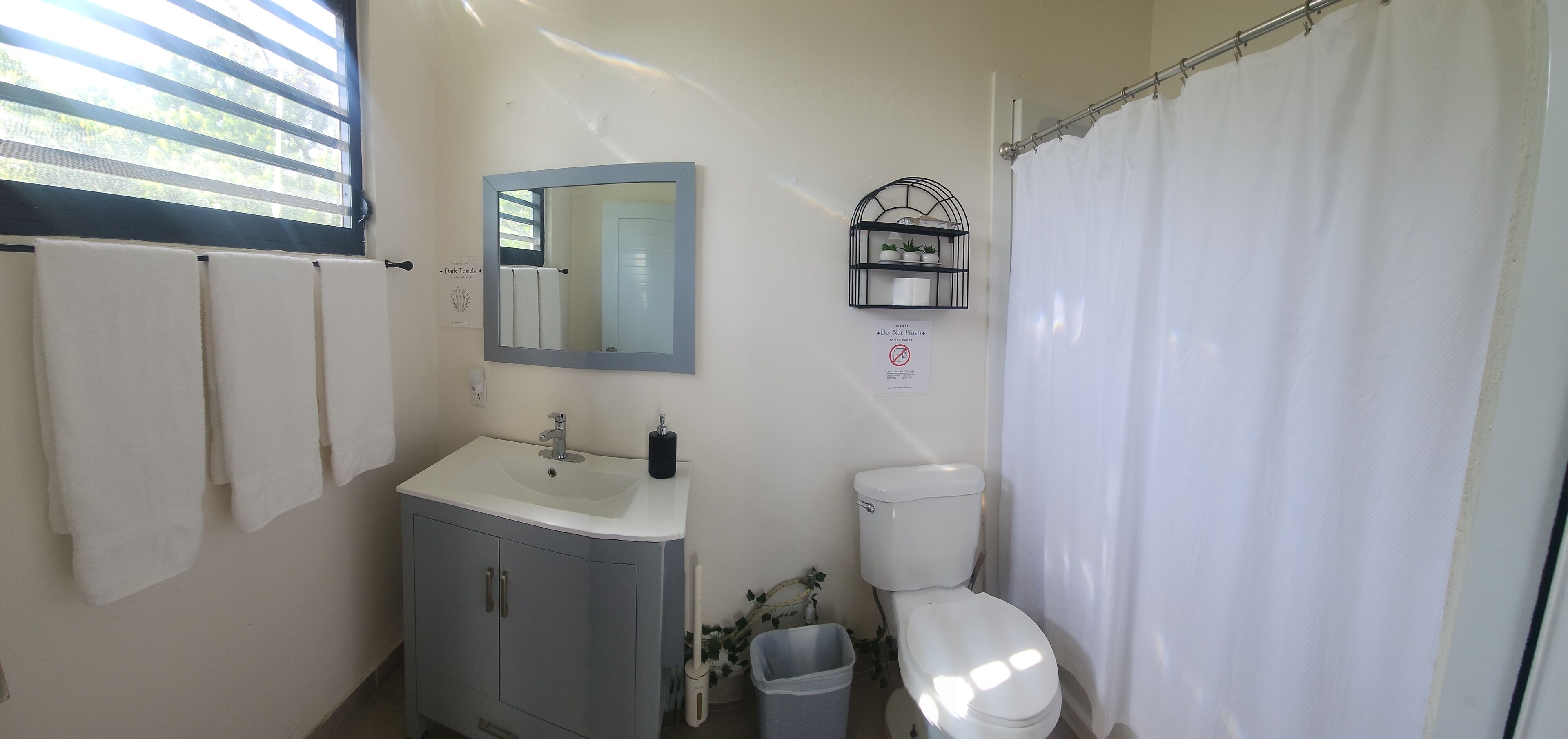Ein Badezimmer mit Waschbecken, Toilette und Duschvorhang.