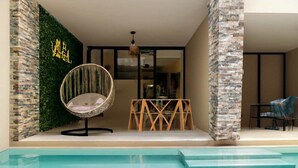A modern outdoor seating area with a pool, a hanging chair, and a wooden table. - Studio with Roof Pool Near Beach (Playa del Carmen)