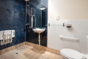 A bathroom with a white toilet, a sink, and a shower area. - Tranquil 3 Bed - All En Suite - Cottage in Hexham (Hexham)